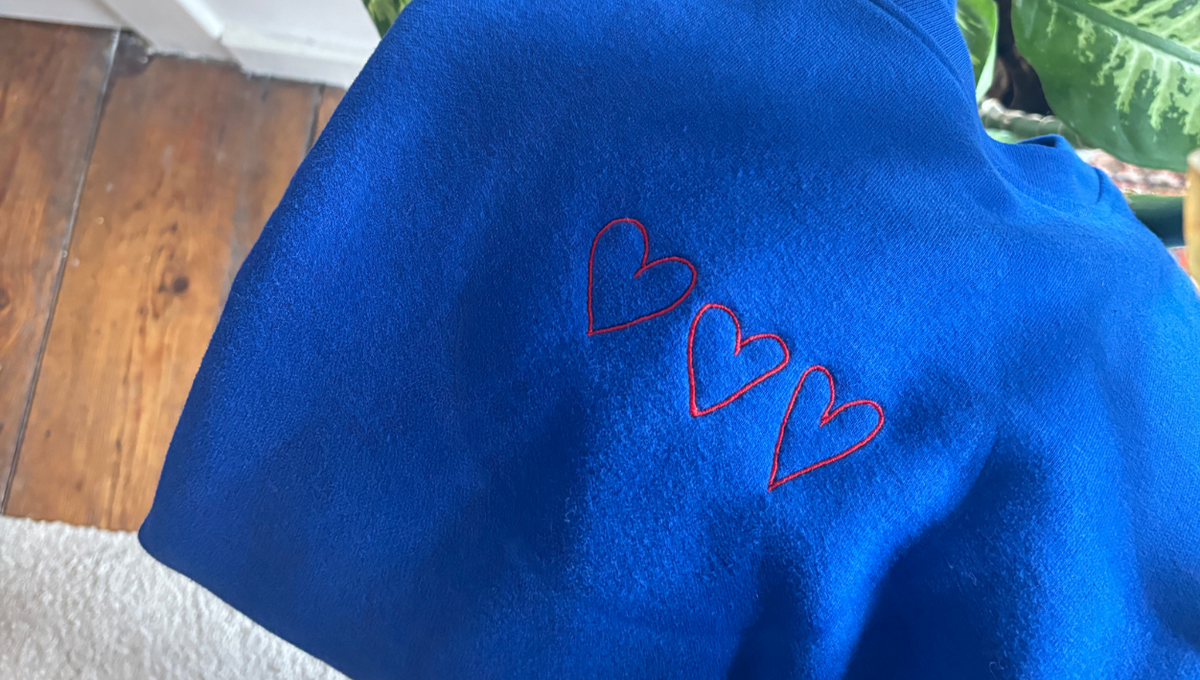 Blauwe trui met drie kleine rode geborduurde hartjes