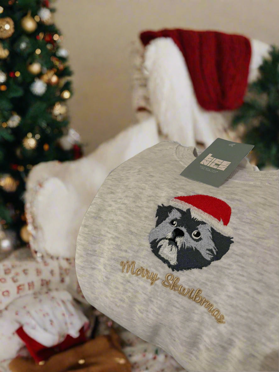 Geborduurde lijntekening van een hond met kerstmuts op een trui