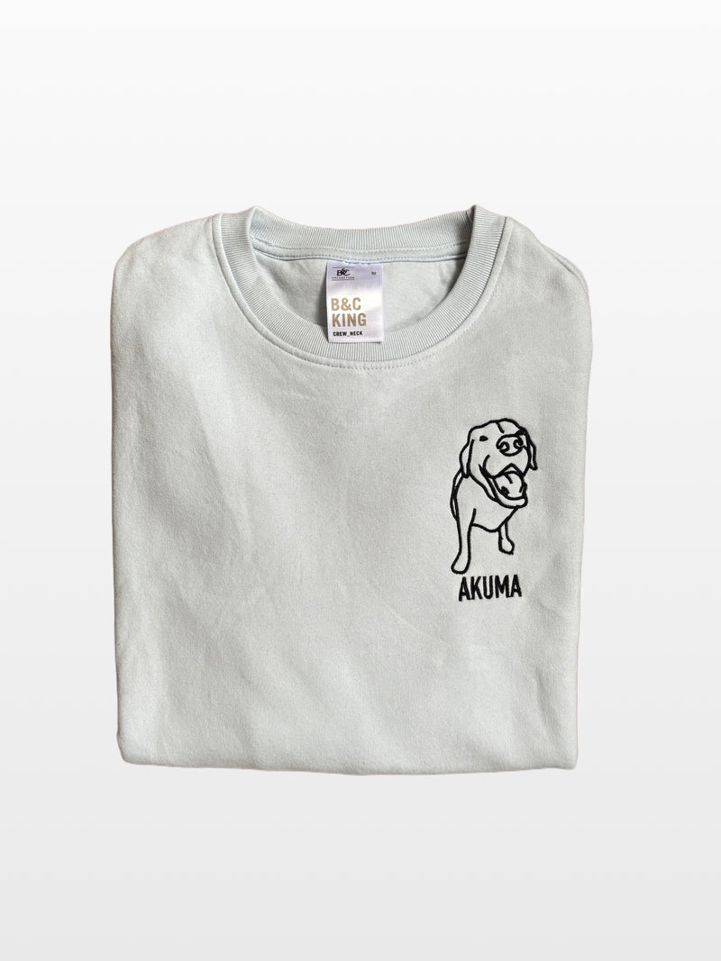 Lichtgrijze sweater met geborduurde lijntekening van een hond en de naam Akuma