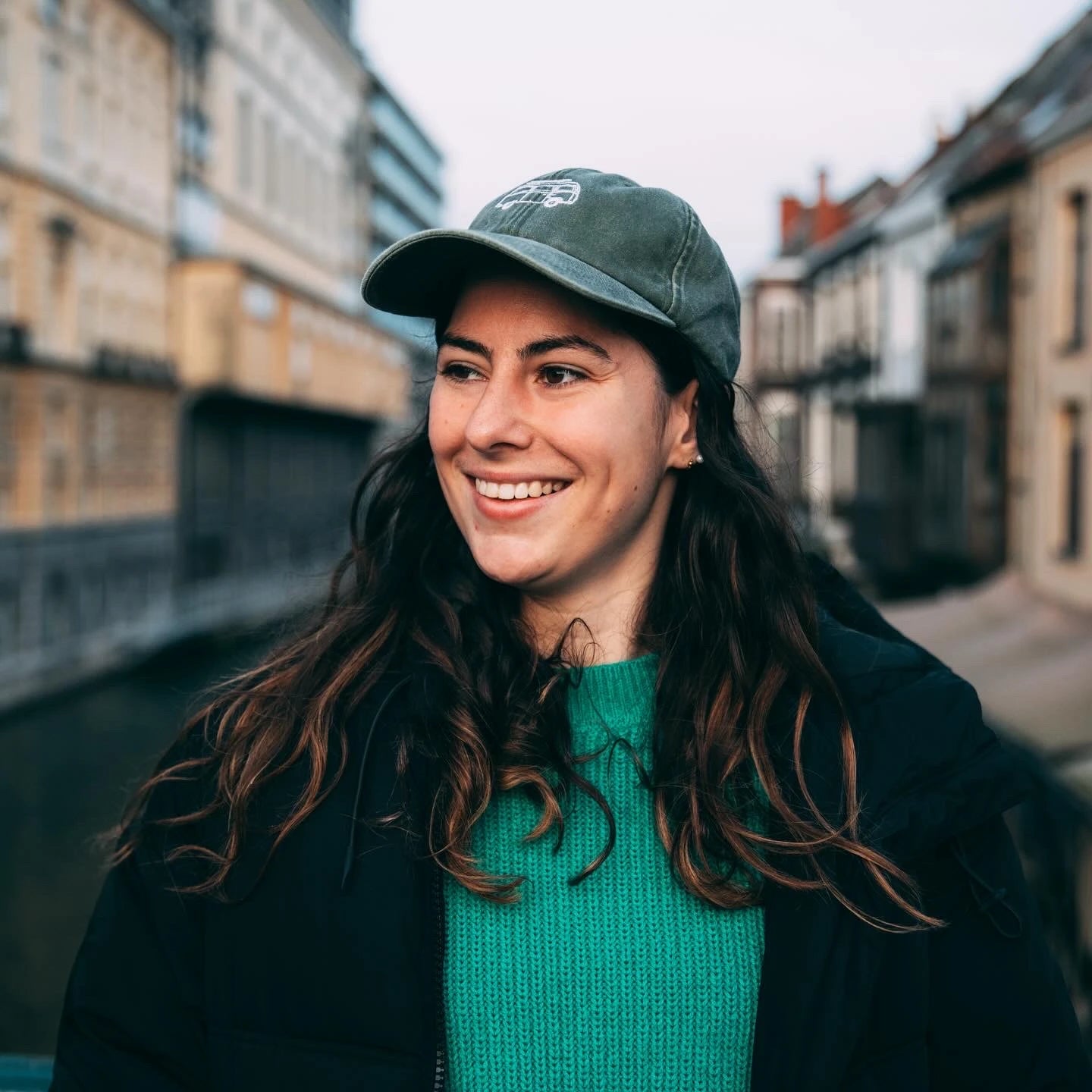 Louise poseert met een gepersonaliseerde pet erop met Ju Kodak als tekst erop geborduurd. Ze draagt ook een gepersonaliseerde trui met een illustratie