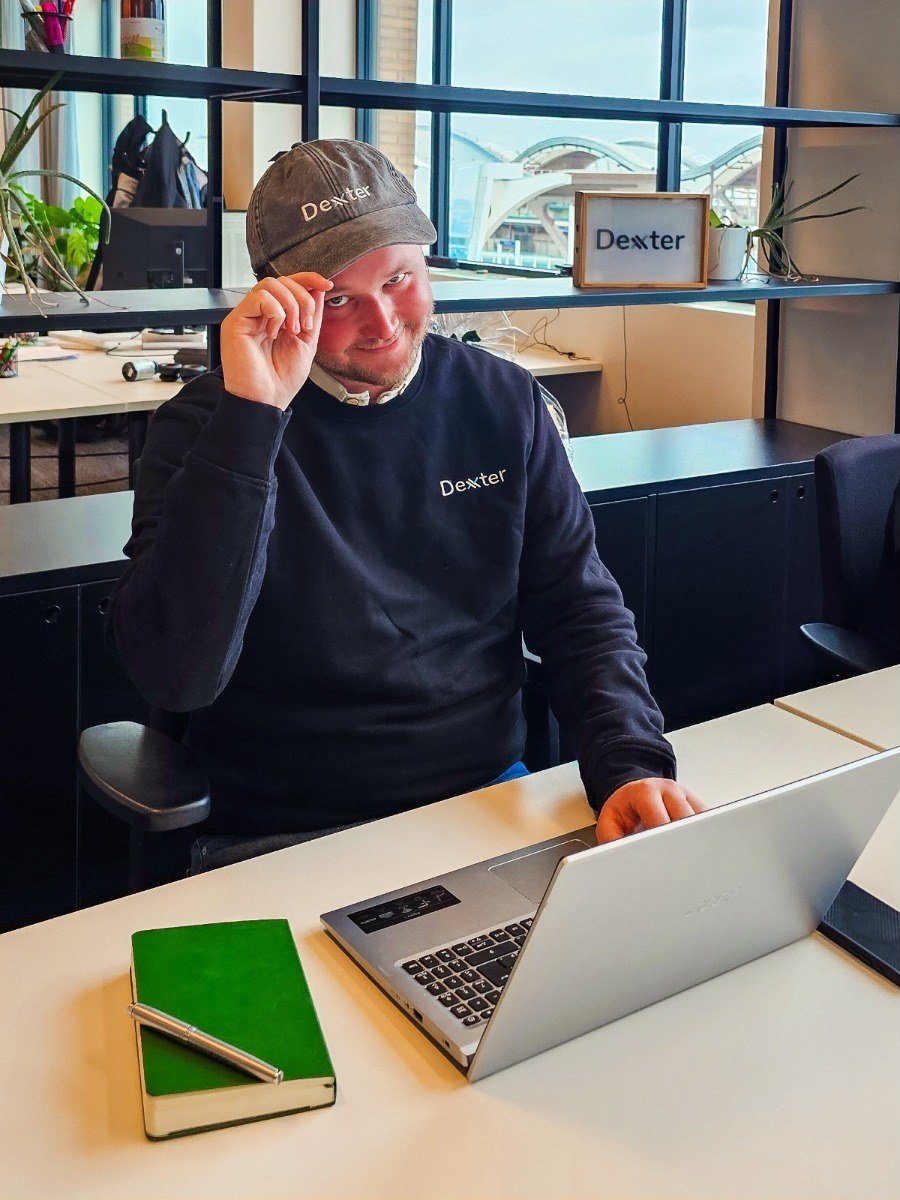 Dexxter employee with embroidered logo on sweater and cap