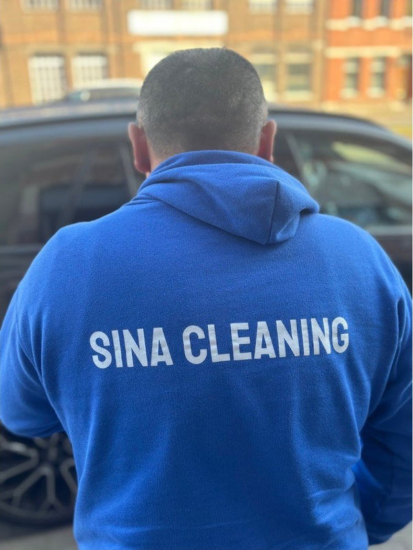 SINA CLEANING op de rug van een blauwe hoodie
