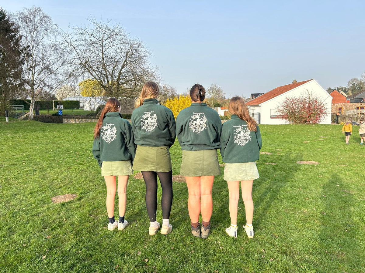 Groupe en pulls brodés de groupe sur l’herbe