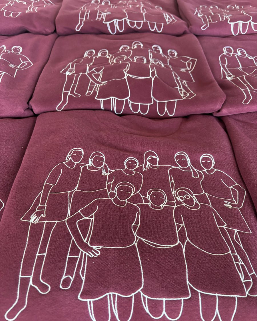 Pulls bordeaux avec un dessin au trait blanc représentant un groupe d’amies