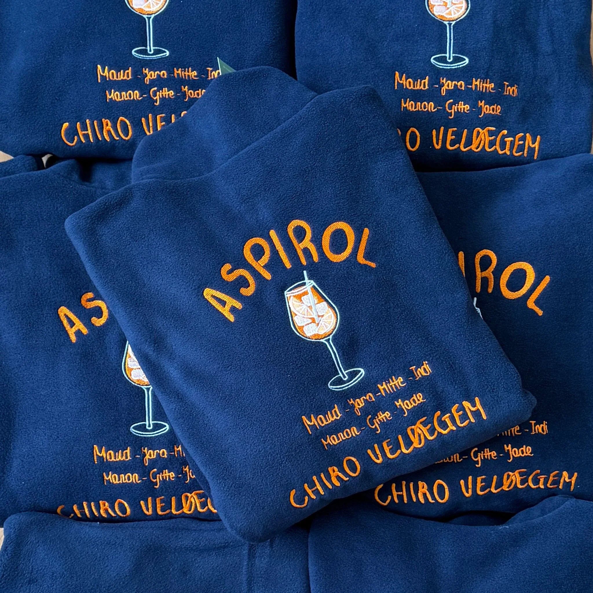 Blauwe groepsfleeces Aspirol voor Chiro Veldegem, geborduurd door Tice Nits