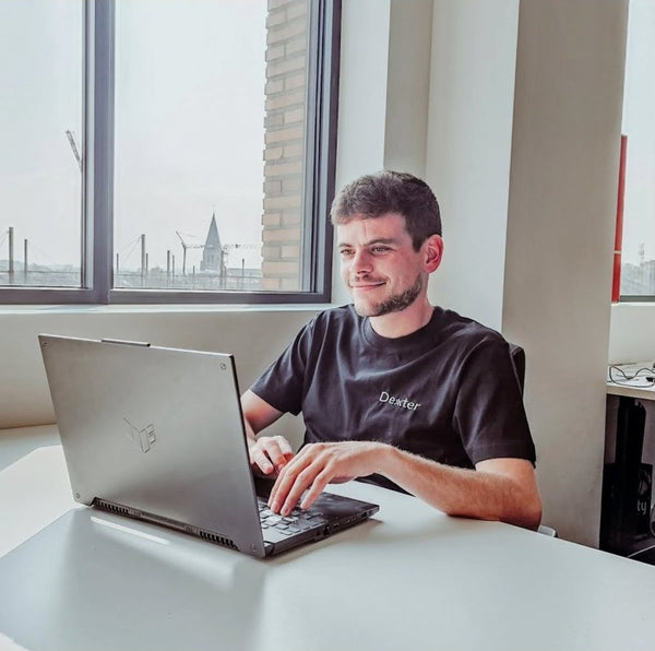 Medewerker aan laptop in T-shirt met logo