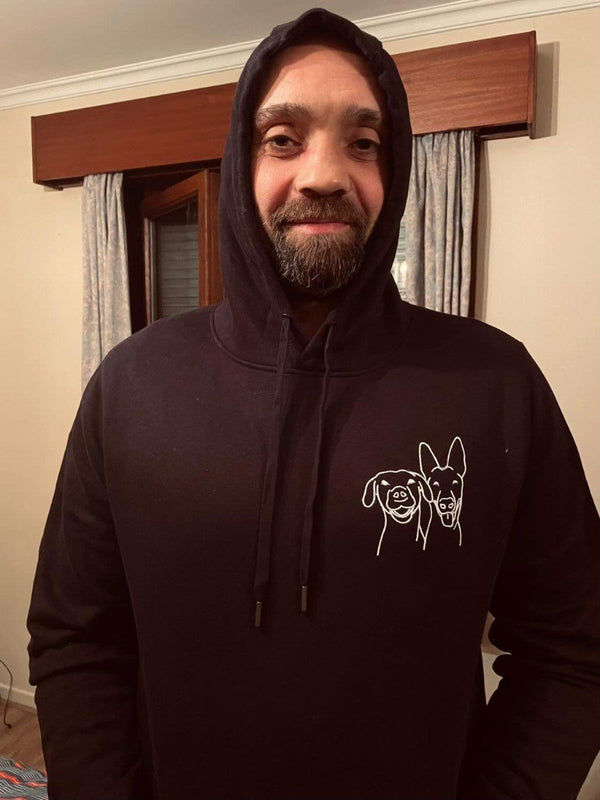 Klant in een zwarte hoodie met lijntekening van zijn twee honden