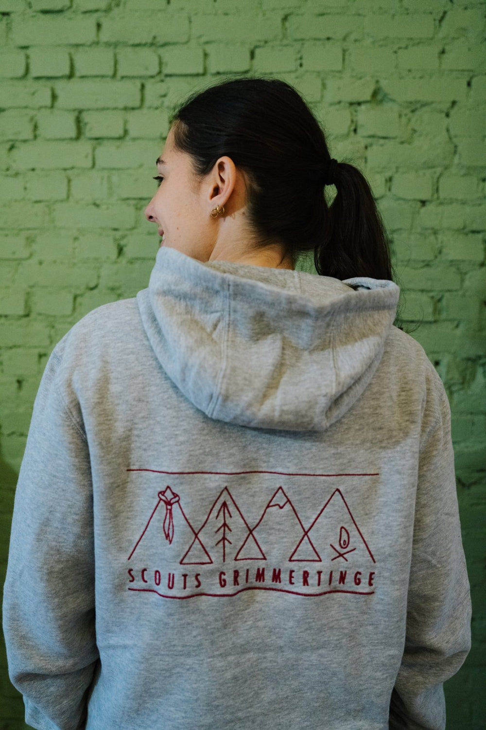 Modèle en sweat à capuche avec logo scout brodé