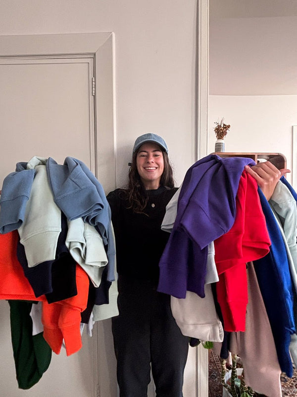 Des piles de pulls de toutes les couleurs dans l’atelier.