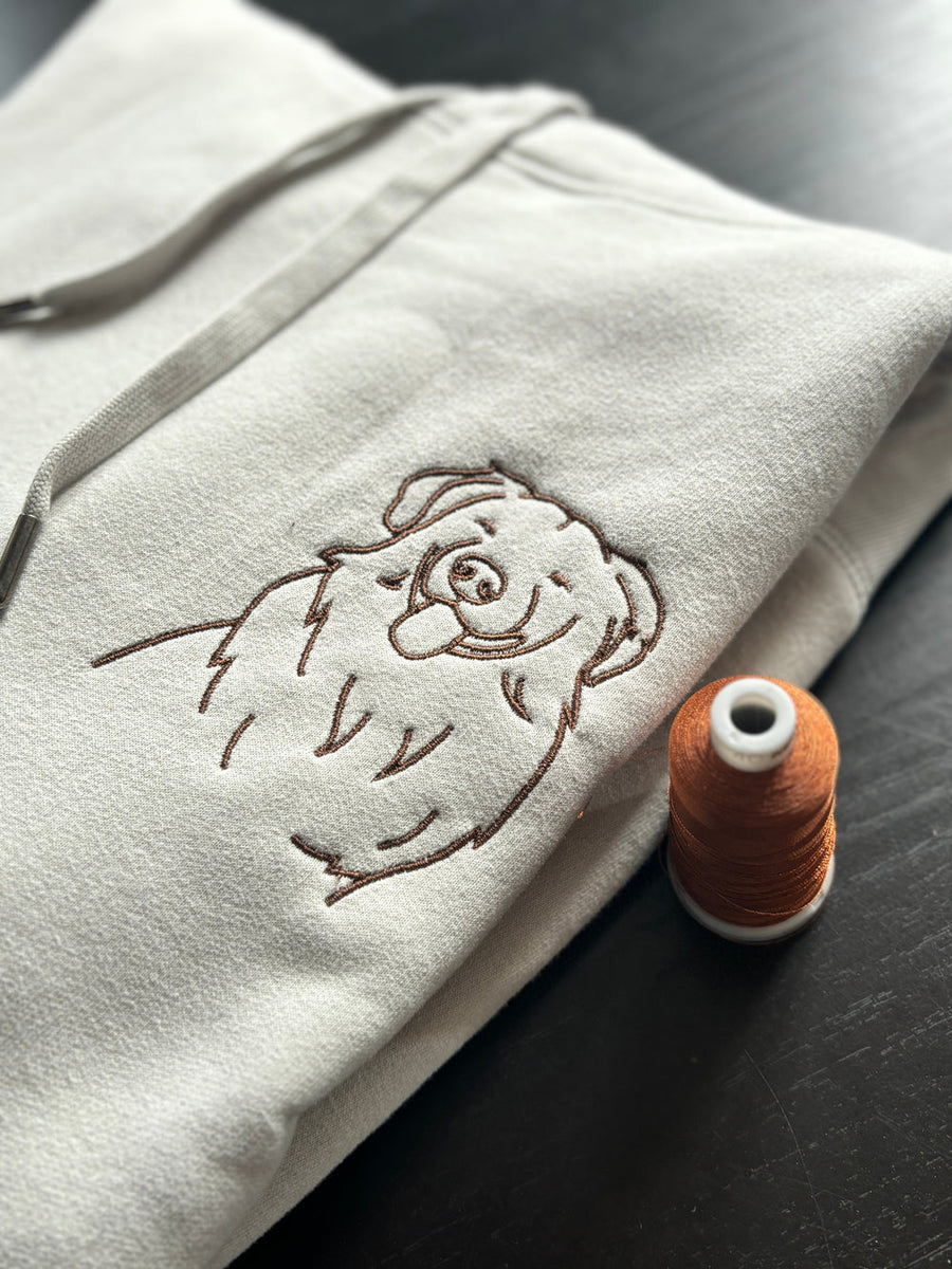 Sweat à capuche gris avec un dessin au trait brodé d'un chien