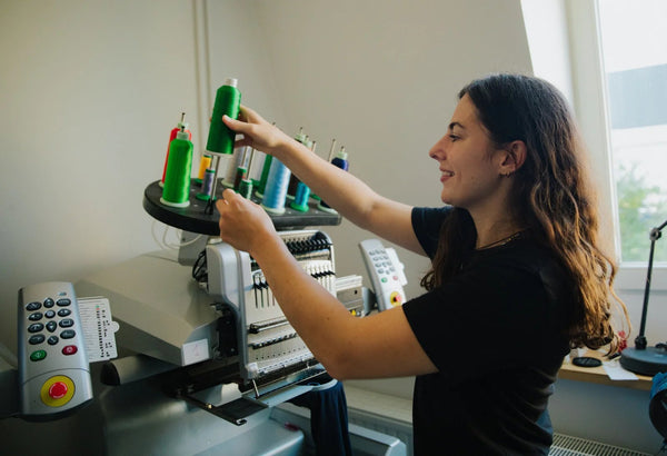 Louise à la machine à broder dans l’atelier de Gand