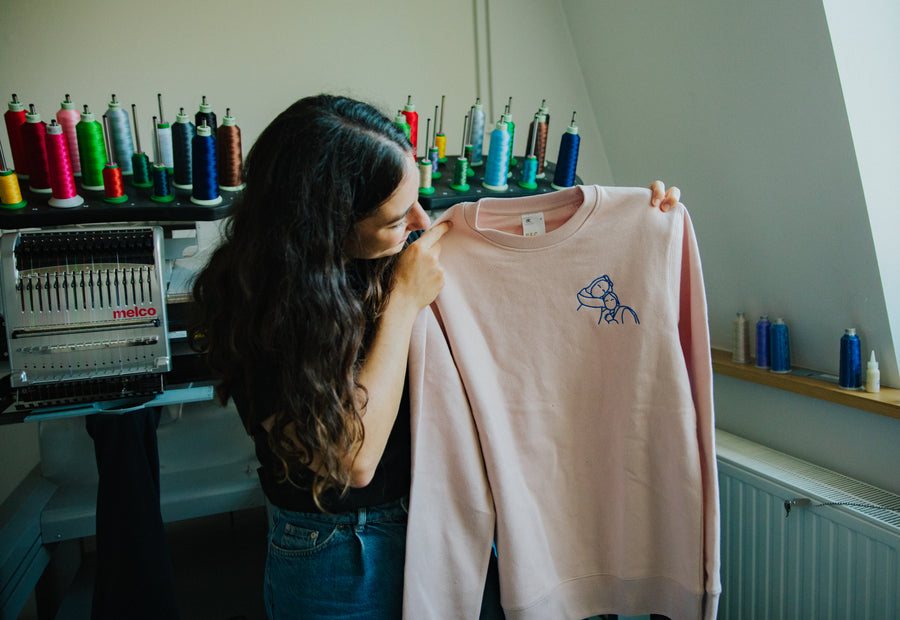 Sweat-shirt rose avec un dessin brodé, tout juste sorti de la machine
