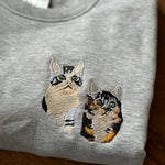 twee katten geborduurd op een sweater