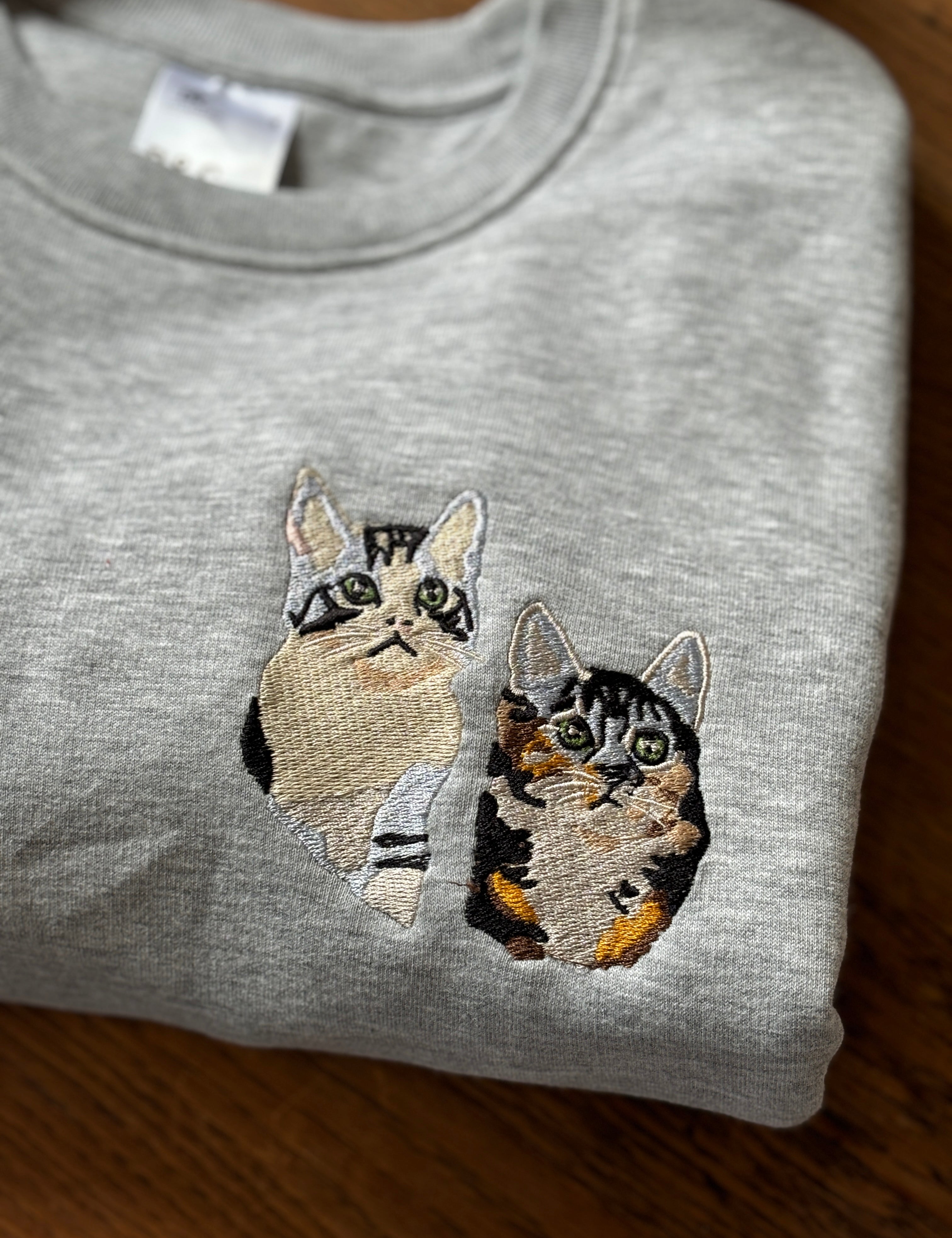 twee katten geborduurd op een sweater