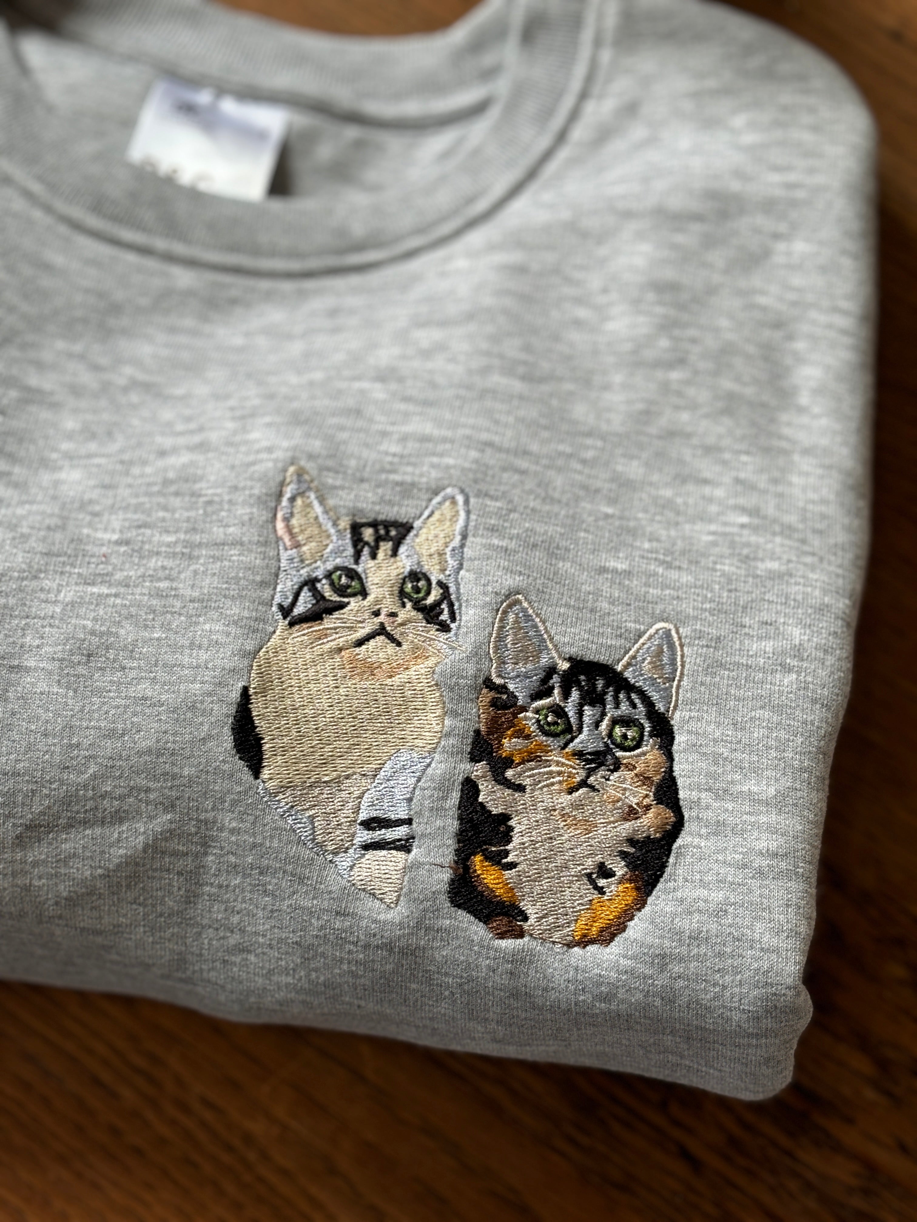 twee katten geborduurd op een sweater