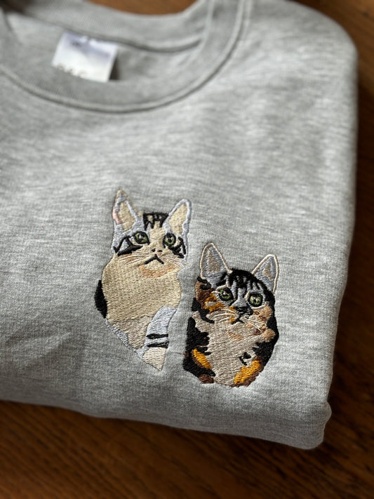 twee katten geborduurd op een sweater